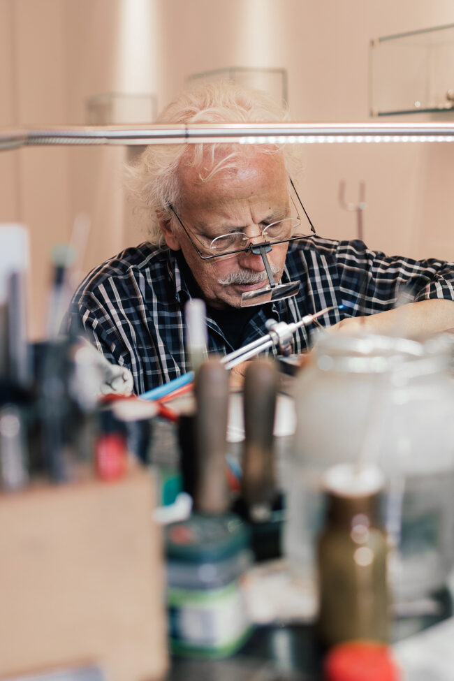 Herr Baus mit Lupe am Arbeiten in Atelier Baus in Mönchengladbach