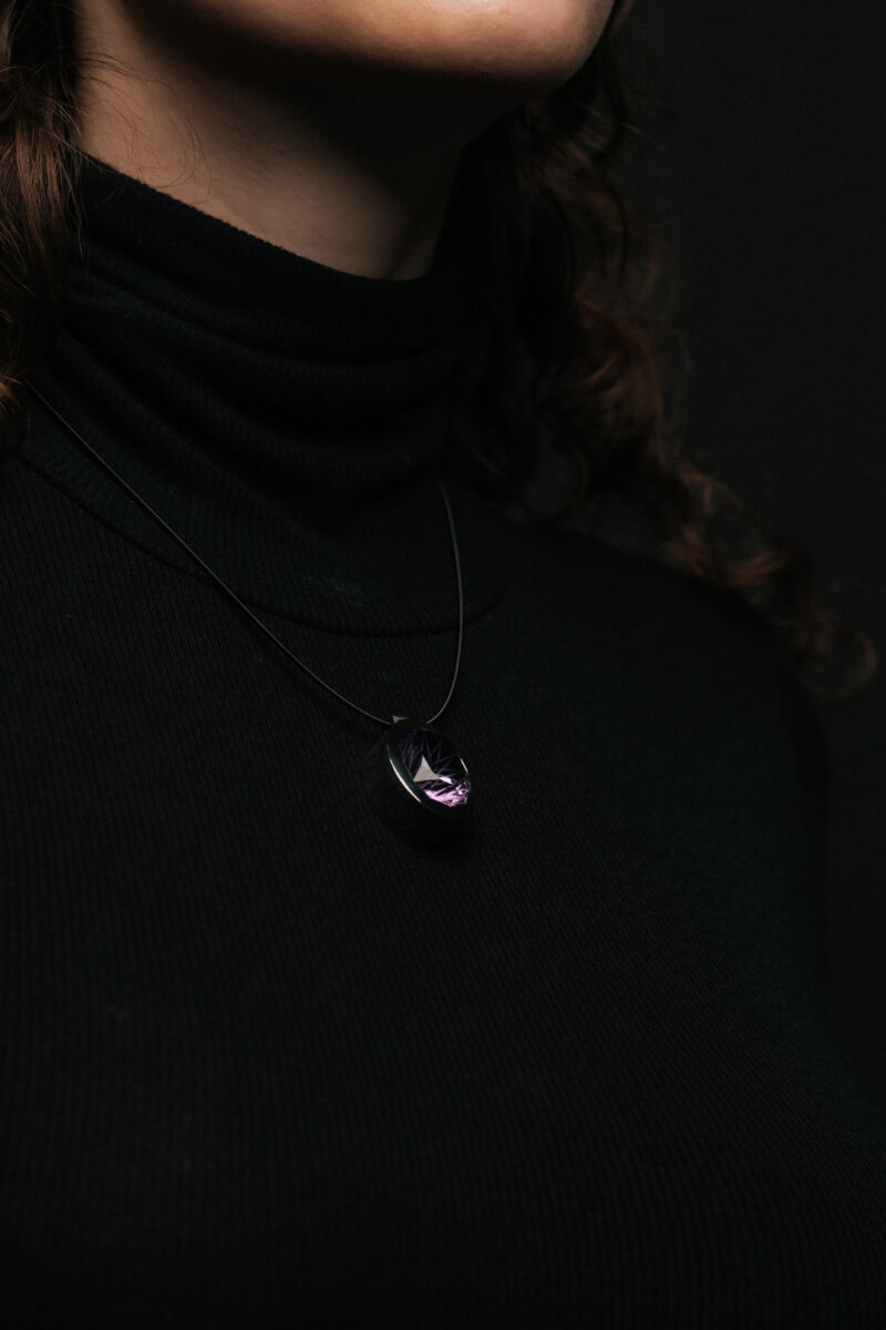 Amethyst Anhänger an Kette auf schwarzem Pullover