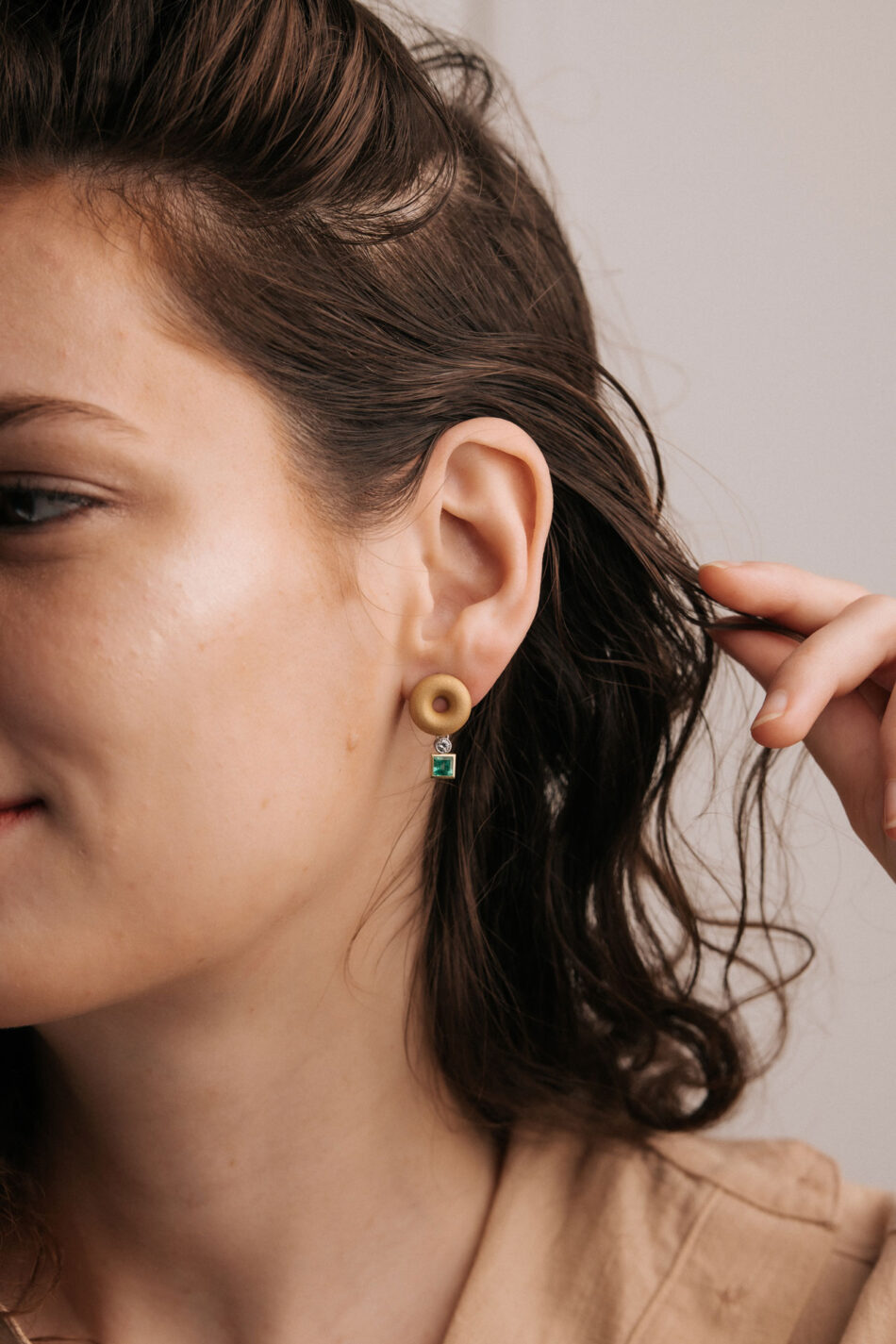 Ohrstecker in gelbgold mit Smaragd und Brillant an Ohr